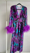 Carica l'immagine nel visualizzatore di Gallery, Abito maxi manica lunga elasticizzato in vita e bottoncini stile corsetto. Fantasia viola e petrolio acquarello, con boa in piuma di struzzo viola ai polsi. Spacco laterale. Attaccatura del boa tramite asoline e bottoncini cuciti a mano, per facilitare il lavaggio e per poterlo utilizzare anche senza piuma.