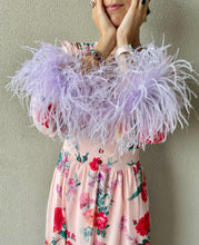 Carica l'immagine nel visualizzatore di Gallery, Abito maxi manica lunga elasticizzato in vita e bottoncini stile corsetto. Fantasia rosa pesca floreale, con boa in piuma di struzzo lilla ai polsi. Spacco laterale. Attaccatura del boa tramite asoline e bottoncini cuciti a mano, per facilitare il lavaggio e per poterlo utilizzare anche senza piuma. Composizione tessuto: 50% polyester; 45% viscose; 5% elastam.