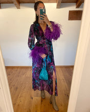 Carica l'immagine nel visualizzatore di Gallery, Abito maxi manica lunga elasticizzato in vita e bottoncini stile corsetto. Fantasia viola e petrolio acquarello, con boa in piuma di struzzo viola ai polsi. Spacco laterale. Attaccatura del boa tramite asoline e bottoncini cuciti a mano, per facilitare il lavaggio e per poterlo utilizzare anche senza piuma.