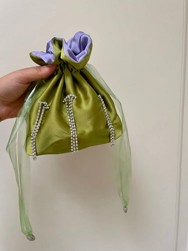 Borsetta mini verde acido handmade in raso esterno con punti luce strass cuciti a mano e raso interno lilla; nastrini in organza verde acido con chiusure a forma di conchiglia argento. Perfetta per completare il tuo outfit da cerimonia. 