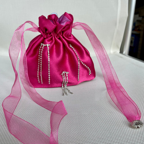 Borsetta mini magenta handmade in raso esterno con punti luce strass cuciti a mano e raso interno a contrasto viola; nastrini in organza magenta con chiusure a forma di conchiglia argento. Perfetta per completare il tuo outfit da cerimonia.   Per ulteriori personalizzazioni scrivici in Direct sulla nostra pagina instagram @jupesandmore oppure compila il form nella sezione 