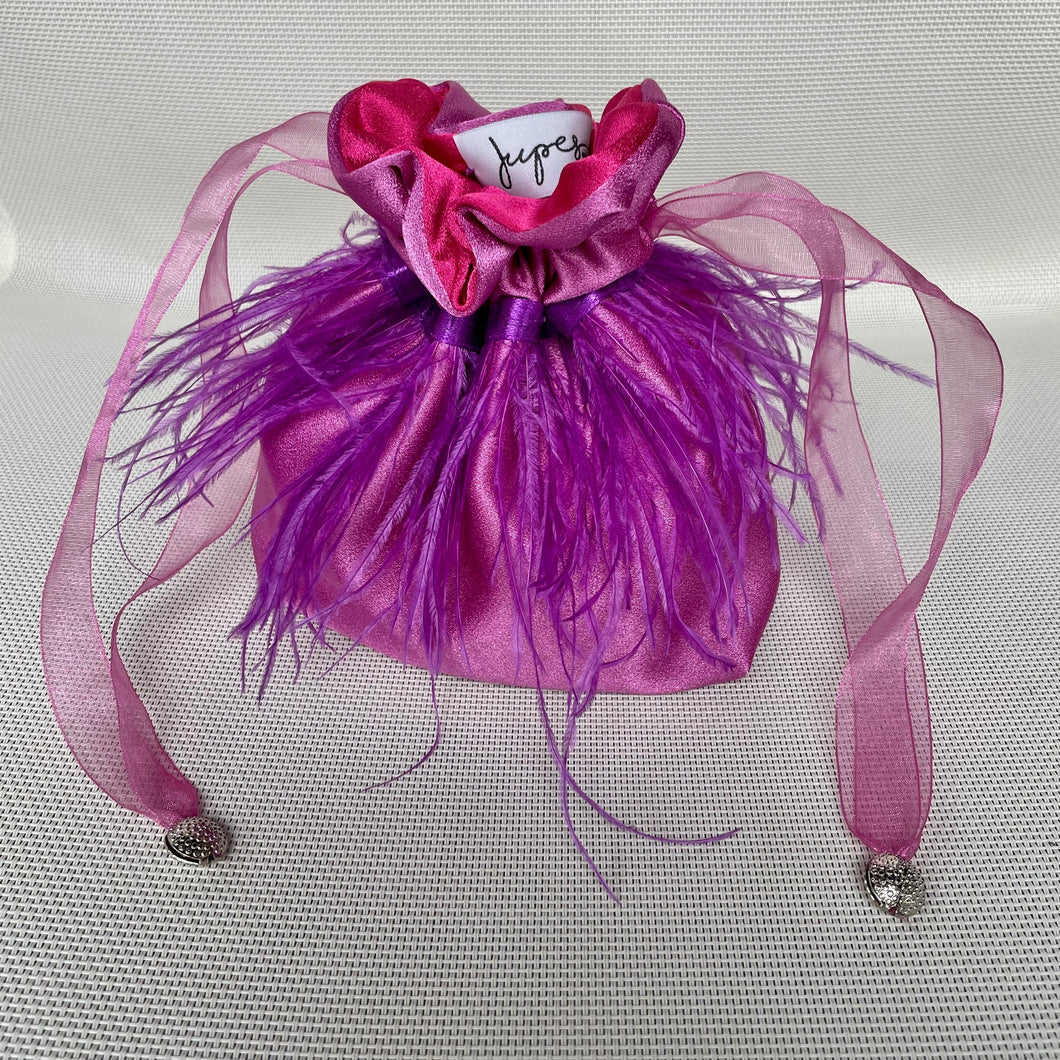 Borsetta mini malva handmade in raso esterno con un giro di piume cucite a mano viola e raso interno a contrasto magenta; nastrini in organza magenta con chiusure a forma di conchiglia argento. Perfetta per completare il tuo outfit da cerimonia.   Per ulteriori personalizzazioni scrivici in Direct sulla nostra pagina instagram @jupesandmore oppure compila il form nella sezione 