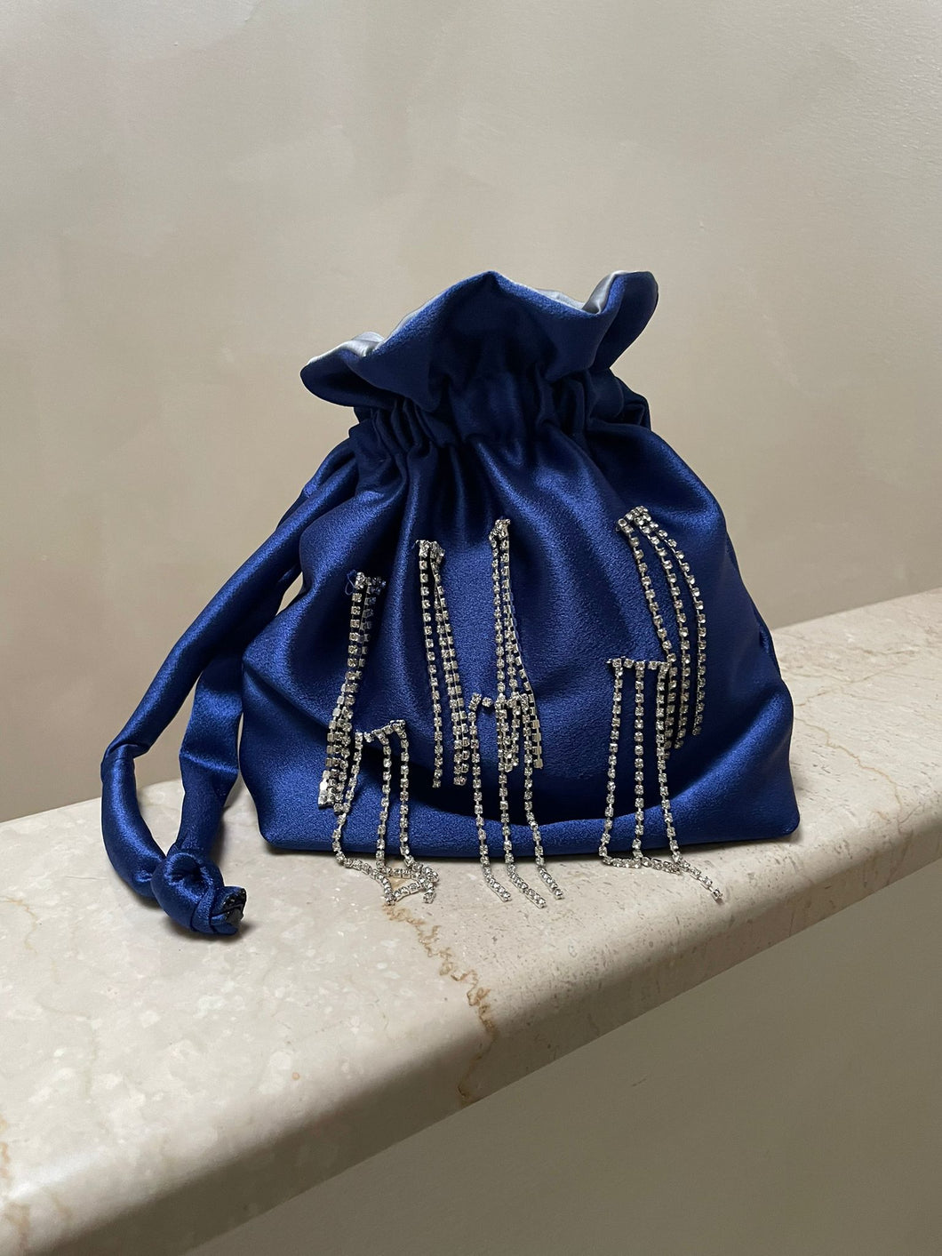 Borsetta midi blu handmade in raso esterno con punti luce strass cuciti a mano e raso interno argento; cordoncini in raso blu con nodo. Perfetta per completare il tuo outfit da cerimonia. 