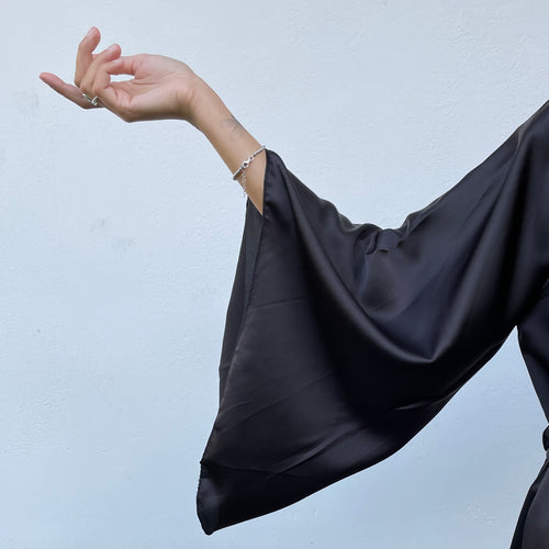 Kimono nero lungo in raso satinato, con spacco laterale e fusciacca in vita. Taglia unica.   Composizione: 100% poliestere.